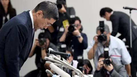 Getty Images Nissan's Chief Executive Hiroto Saikawa bows in apology
