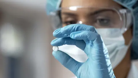 Getty Images Scientist holding a drug