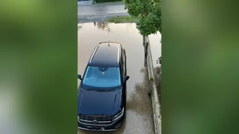 Andi Siago Car on a flooded driveway