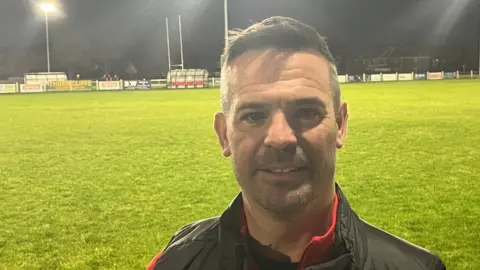 Rhyl Rugby Club chairman Gareth John standing on the club's pitch.