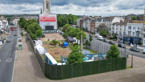 An aerial shot of Brighton Euro fan zone. A patch of land next to a church surrounded by green fence panelling