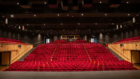 Stage view of the auditorium, of 800 red empty seats.