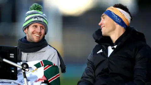 Getty Images Ex-Leeds Rhinos rugby league player Kevin Sinfield (R) speaks with former teammate Rob Burrow after completing his Extra Mile Challenge at Emerald Headingley Stadium