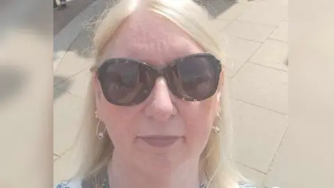 Alison Moss A selfie of Alison Moss, a blonde-haired woman wearing sunglasses