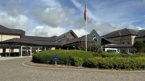The front entrance to Noble's Hospital has a paved road around it.