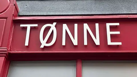 The sign for Tonne on the front of the building