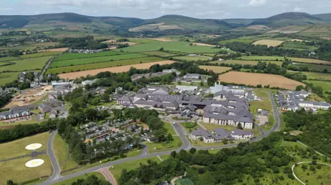 The Noble's Hospital site from above, which shows the main hospital and car park along with two helipads.