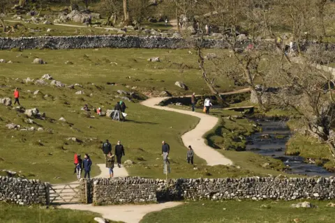 Getty Images Visitors walking along the river close to the village of Malham