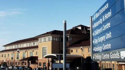 PA Media The entrance sign to Nottingham City Hospital with the hospital building in the background