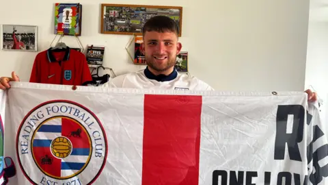 Charlie is posing and holding his thatcham royals flag