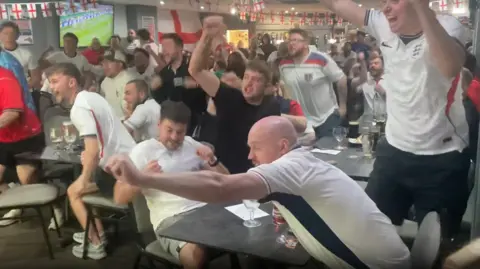 Fans celebrating one of the goals in a pub