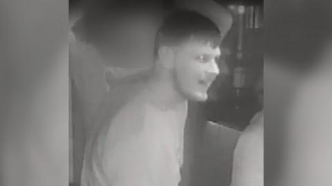A black and white CCTV image of a man