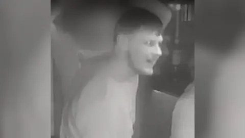 Avon and Somerset Police A black and white CCTV image of a man