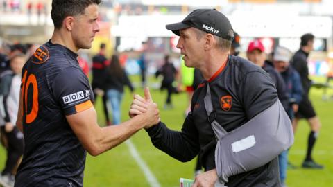 Armagh manager Kieran McGeeney shakes hands with forward Stefan Campbell after the 11-point win over Derry at Celtic Park