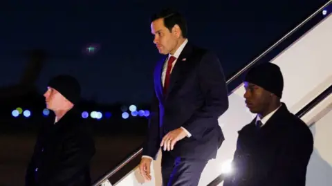 Reuters Marco Rubio disembarks a plane as he returns to Andrews Air Force Base, 13 February