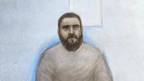 Elizabeth Cook/PA Wire Court artist sketch by Elizabeth Cook of Mohammad Bashir appearing at the Old Bailey in London, where he is charged with terrorism offences for allegedly assisting Manchester synagogue attacker Jihad Al-Shamie. Bashir, 31, has been charged with four terrorism offences, including preparation for acts of terrorism, following allegations he drove Al-Shamie to the UK Defence Academy in Shrivenham, Oxfordshire, on August 14.