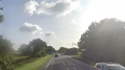 Google Google street view image of the A47 near Dereham on a sunny day. There are a couple of cars on the road but it is not busy. 