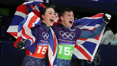 Tabitha Stoecker and Matt Weston celebrate winning gold in the team skeleton event at the Winter Olympics in Milan-Cortina