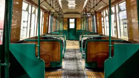 Inside one of the Q stock carriages - there are wooden floors as well as  are green poles and edges