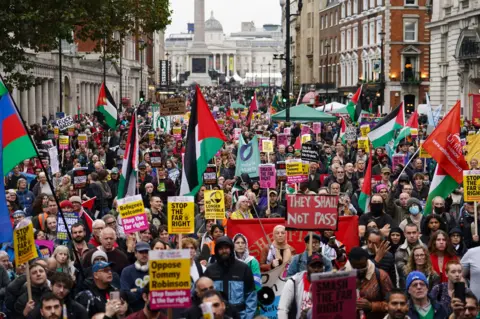 PA Media Numerous protesters in Whitehall holding placards and flags