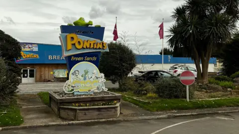 The main entrance to Pontins Brean Sands in Brean with the company logo in yellow letters on a blue background