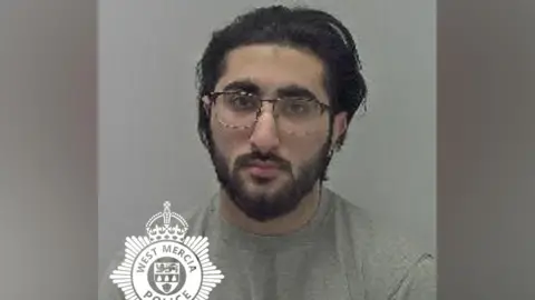 West Mercia Police A mug shot of Haider Ali who has long dark hair and dark facial hair. He wears black glasses and is wearing a grey jumper