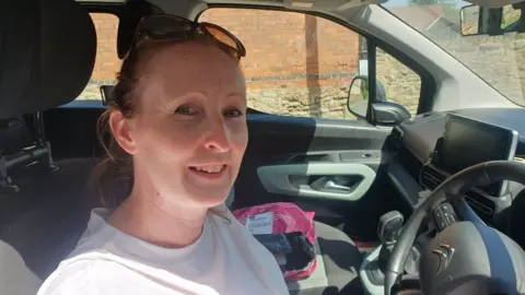 Woman through car window looking at camera