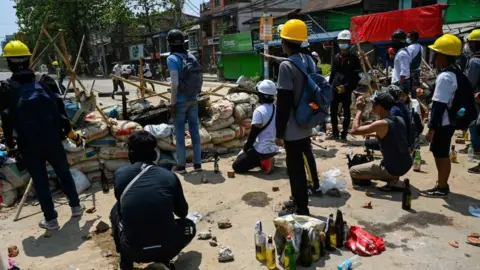 Getty Images Protesters against the coup in Myanmar at barricades in Yangon's Thaketa township on Friday