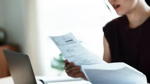 Getty Images Girl sorting bills