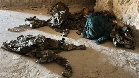 Military uniform scattered on land 