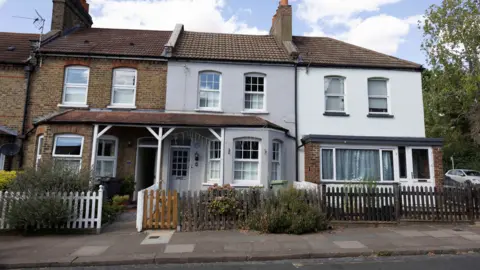 A row of terraced houses with the grey former Bowie family home in the centre