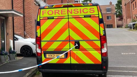 The rear view of a forensics van parked outside a residential street