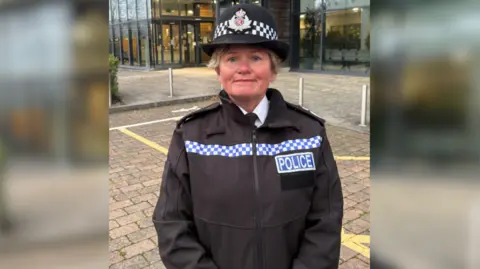 PA Media Temporary Chief Constable Maggie Blyth from Gloucestershire Constabulary. She is wearing a black coat with reflective chequerboard pattern and the word POLICE written across it.