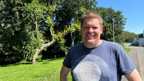 Marc Winn in front of a tree, looking at the camera 