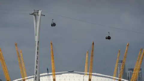 PA Media A line of cable car cabins hangs over the 02