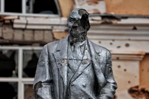 Getty A damaged statue of Lenin stands in Sudzha after fighting in August