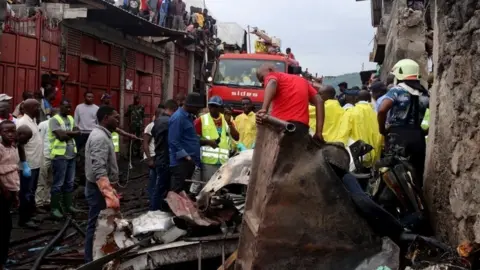 Reuters Rescuers and civilians gather at the site where a Dornier 228-200 plane operated by local company Busy Bee crashed into a densely populated neighborhood in Goma, eastern Democratic Republic of Congo November 24, 2019.