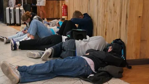 PA Media Passengers trying to sleep, Luton Airport