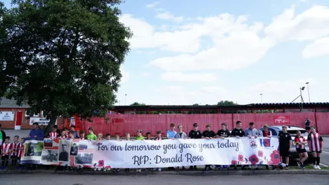 Jacob King/PA Wire Children hold a banner for Donald Rose