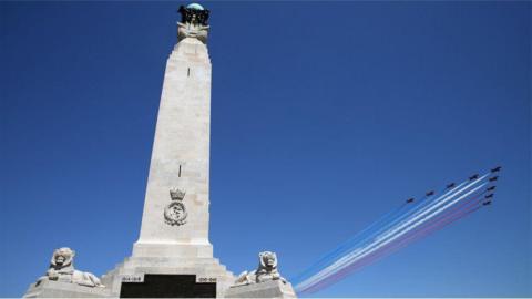 Red Arrows flying over Portsmouth war memorial in clear blue sky on 70th anniversary of D-Day