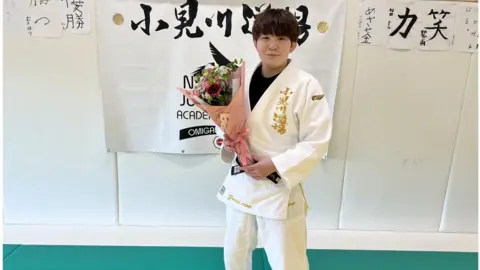 Rina Gonoi Rina Gonoi holding bunch of flowers in Judo uniform