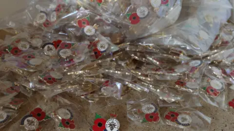 Derbyshire County Council A pile of fake Poppy pin badges in plastic wrapping