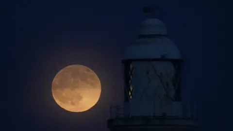 PA Media Wolf moon seen over St Mary's lighthouse at Whitley Bay in Northumberland