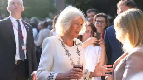 Getty Images Queen Camilla chats with a guest at the garden party