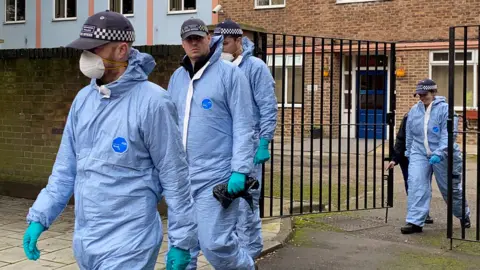Getty Images Forensic officers at flats