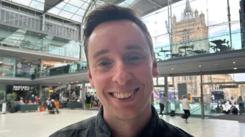 Imogen Lee/BBC A head and shoulders image of a man with short brown hair. He is smiling at the camera.