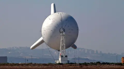 Getty Images IDF observation balloon pictured in 2021. It looks like a blimp or airship with three large fins at the rear.