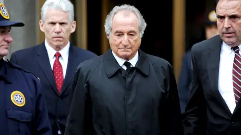 EPA Financier Bernard Madoff (C), who has been charged with allegedly running a $50 billion "Ponzi scheme" leaves federal court following a hearing in New York, New York, USA, on 10 March 2009 (reissued 14 April 2021). Madoff has died in prison aged 82, the Federal Bureau of Prisons confirmed to several media