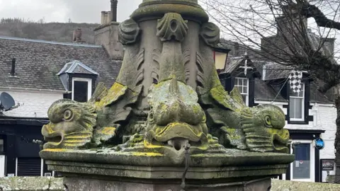a fountain with fish heads