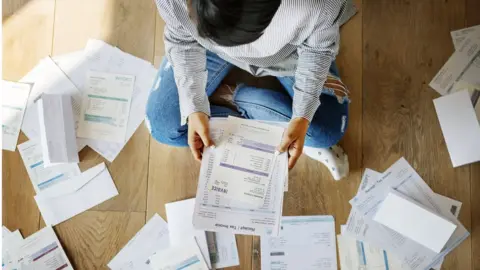 Getty Images Woman looking at bills